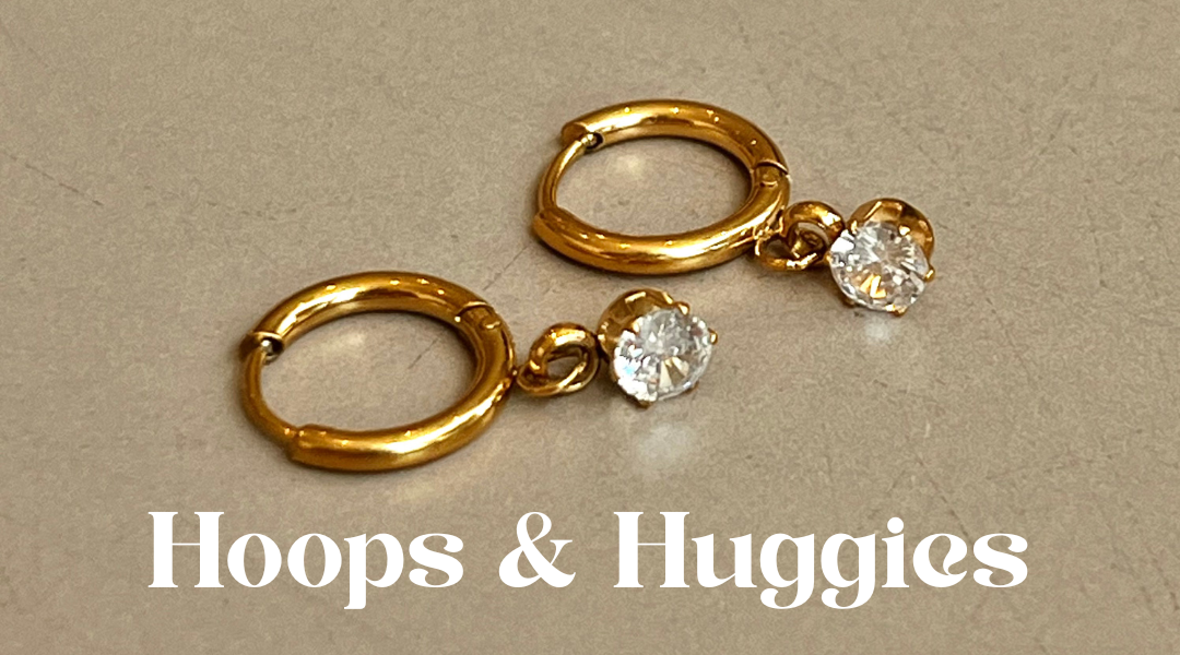 Gold hoop earrings with small diamonds on a beige background, featuring 'Hoops & Huggies' text.