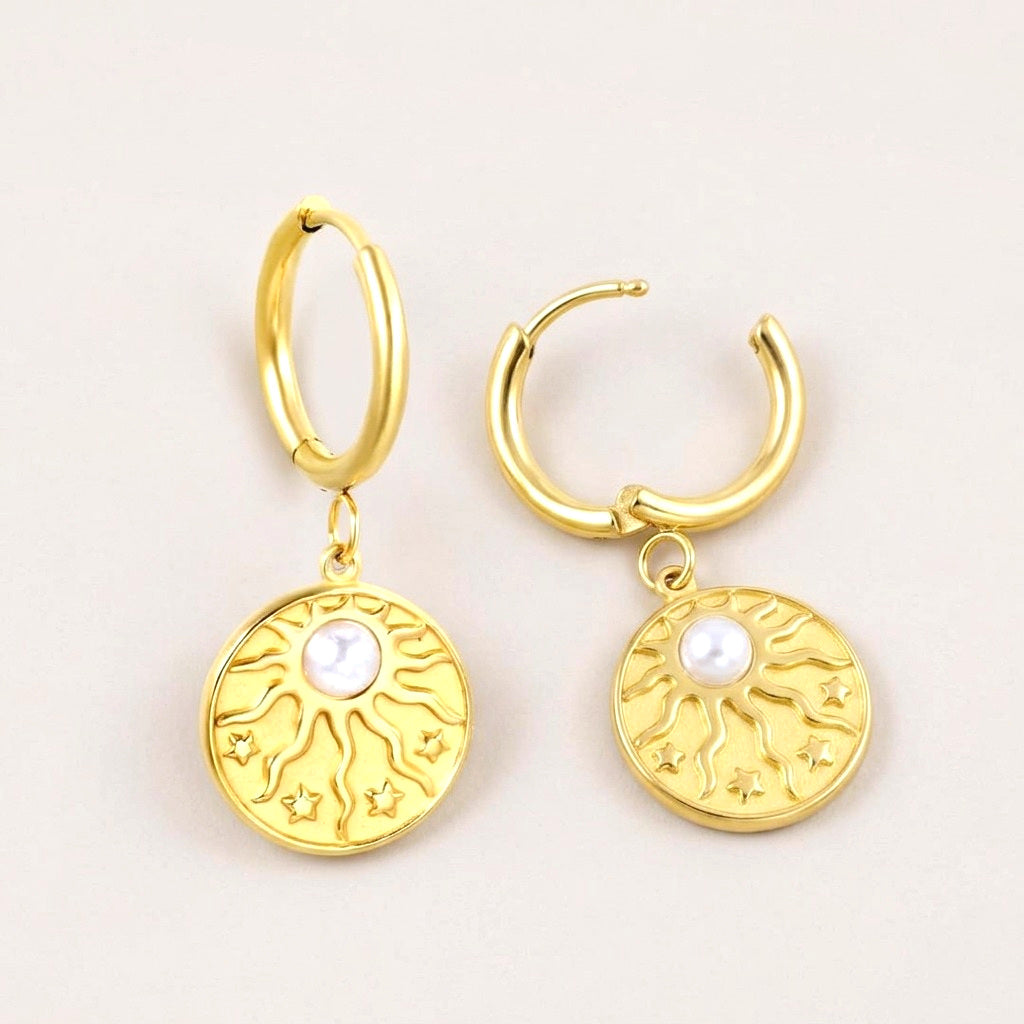 Celeste Coin Golden Huggies: hypoallergenic huggie hoop earrings, shown front and side on a soft stone background