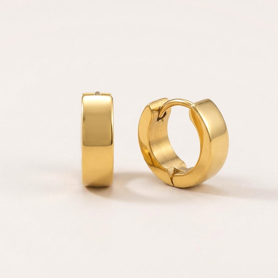 Classic Bold Huggies Gold: hypoallergenic huggie hoop earrings, shown front and side on a soft stone background