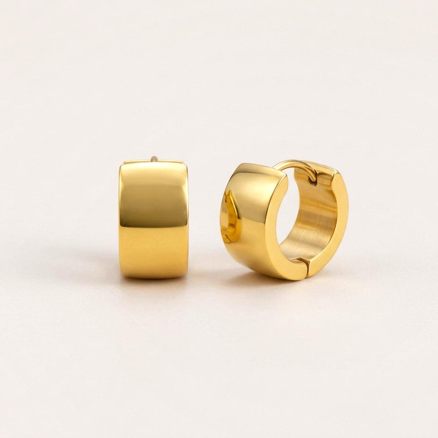 Classic Chunky Huggies Gold: hypoallergenic huggie hoop earrings, shown front and side on a soft stone background