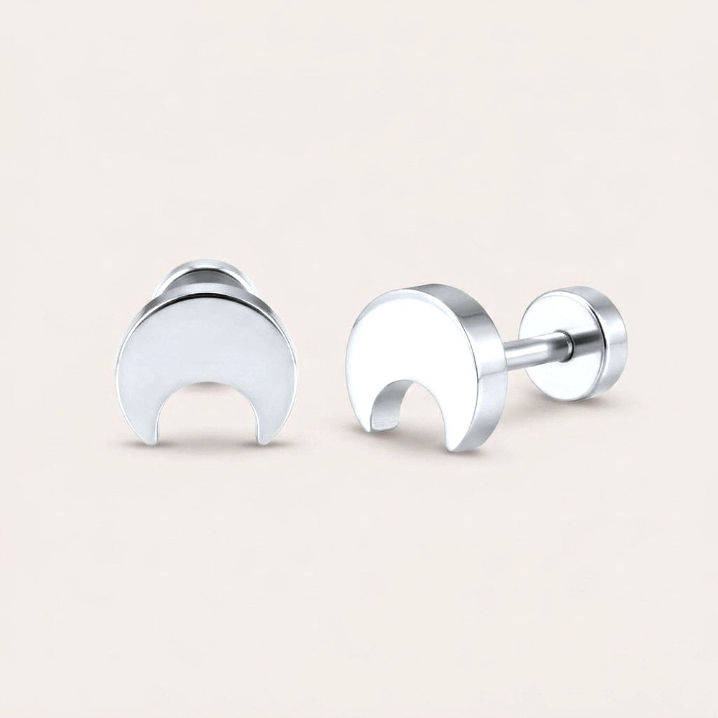 Crescent Flat Back Stud Silver: hypoallergenic kids' flat back stud earrings, shown front and side on a soft stone background
