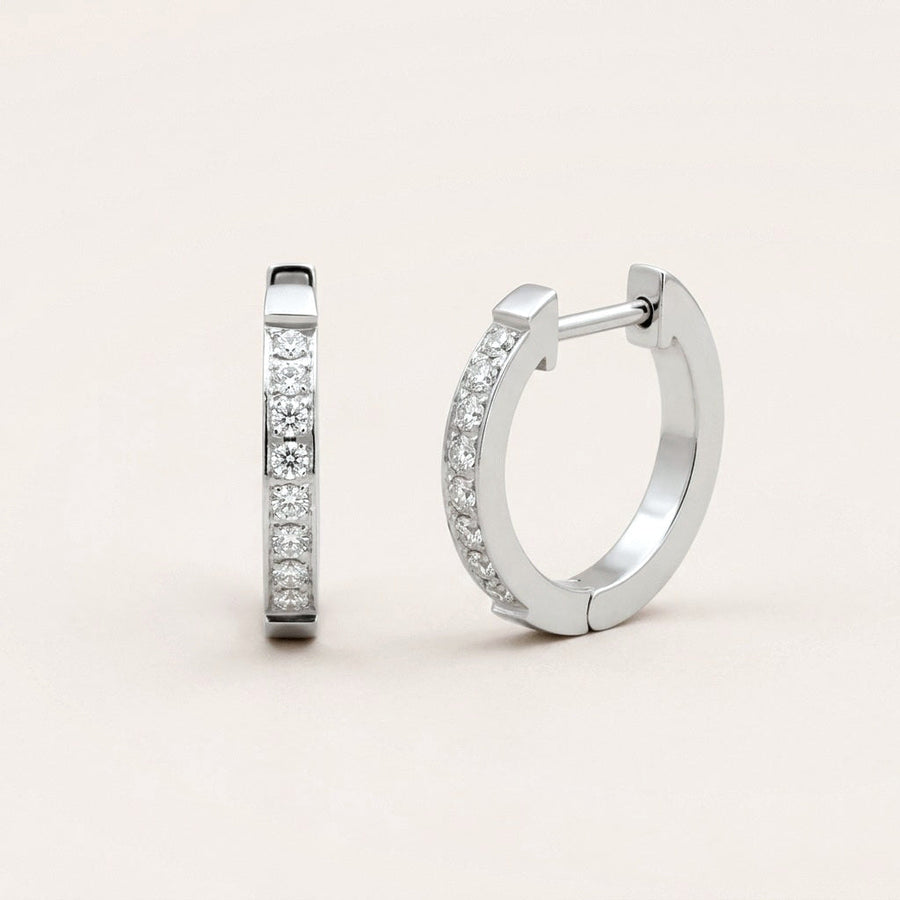 Everyday Sparkle Huggies Silver: hypoallergenic huggie hoop earrings, shown front and side on a soft stone background