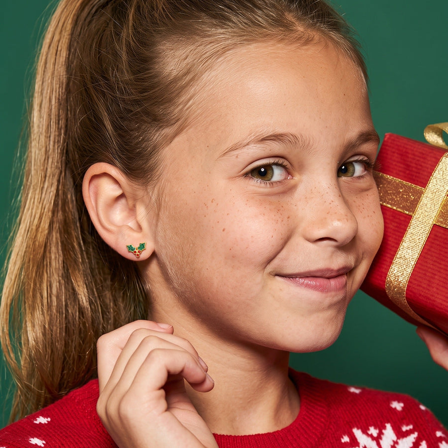 Holly Flat Back Studs worn by a smiling girl, christmas look: hypoallergenic kids' earrings