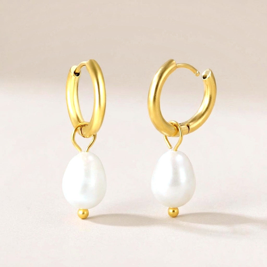Luna Pearl Drop Huggies Gold: hypoallergenic huggie hoop earrings, shown front and side on a soft stone background