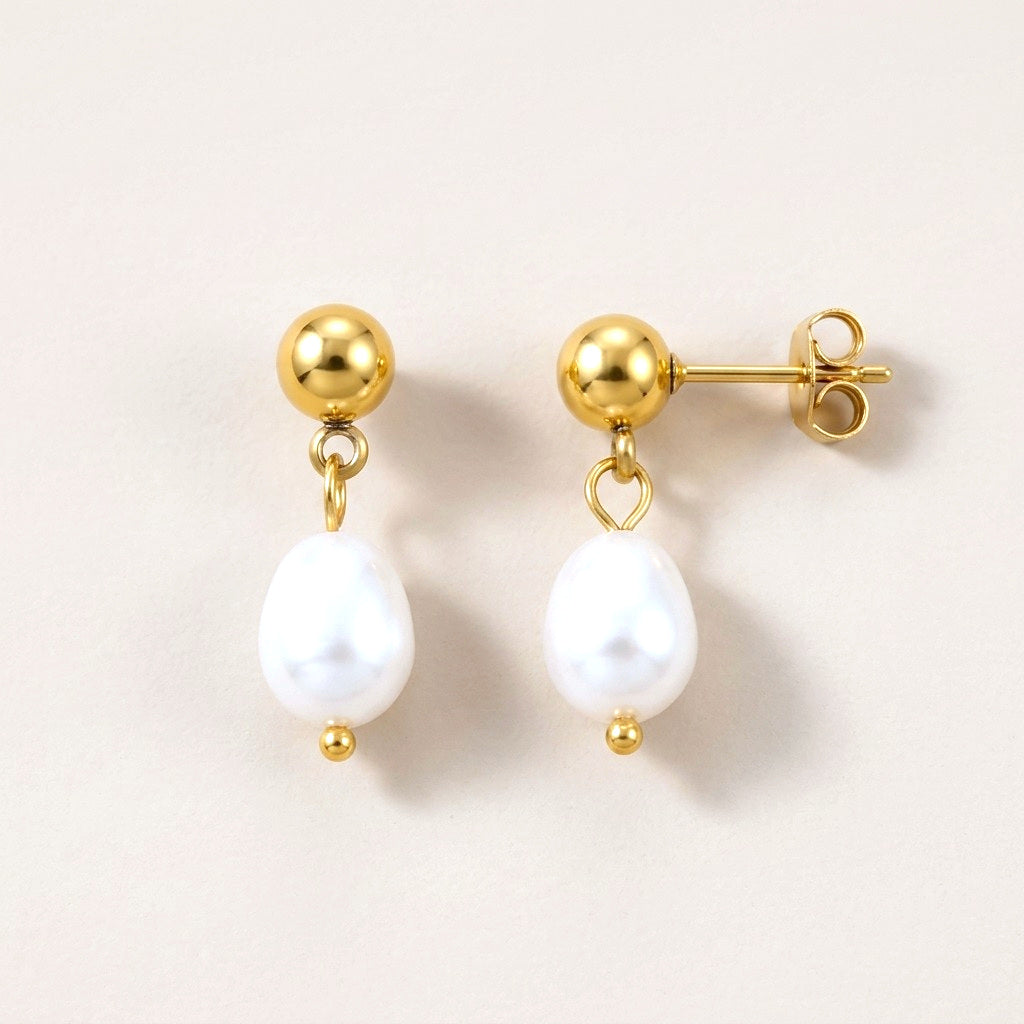Pearl Drop Studs: hypoallergenic stud earrings, shown front and side on a soft stone background