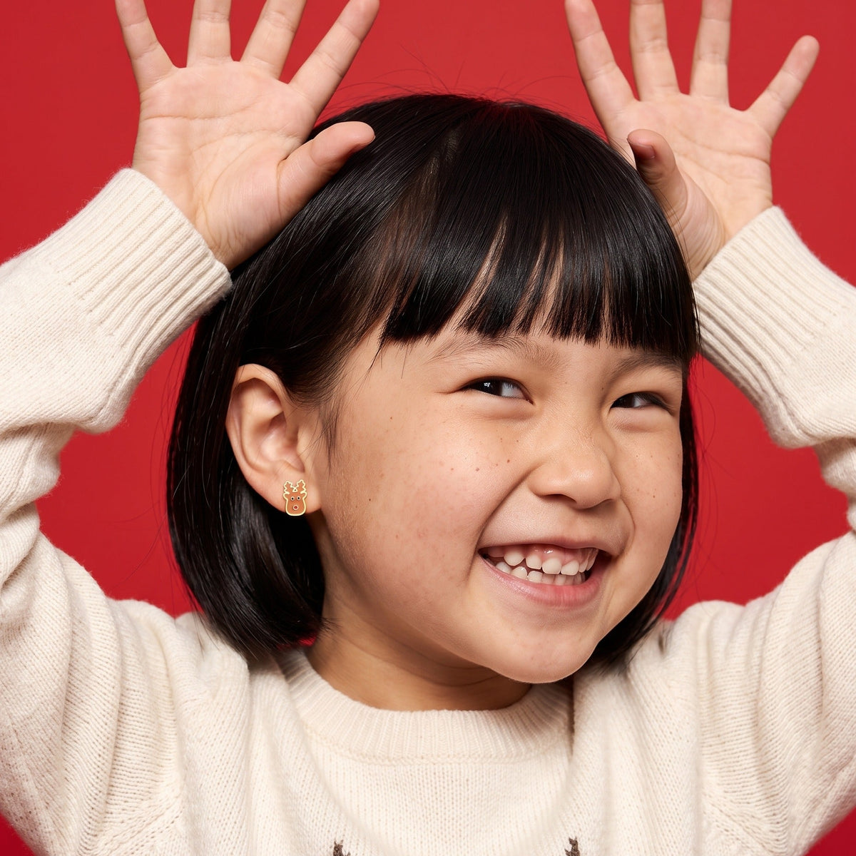 Reindeer Flat Back Studs worn by a smiling girl, christmas look: hypoallergenic kids' earrings