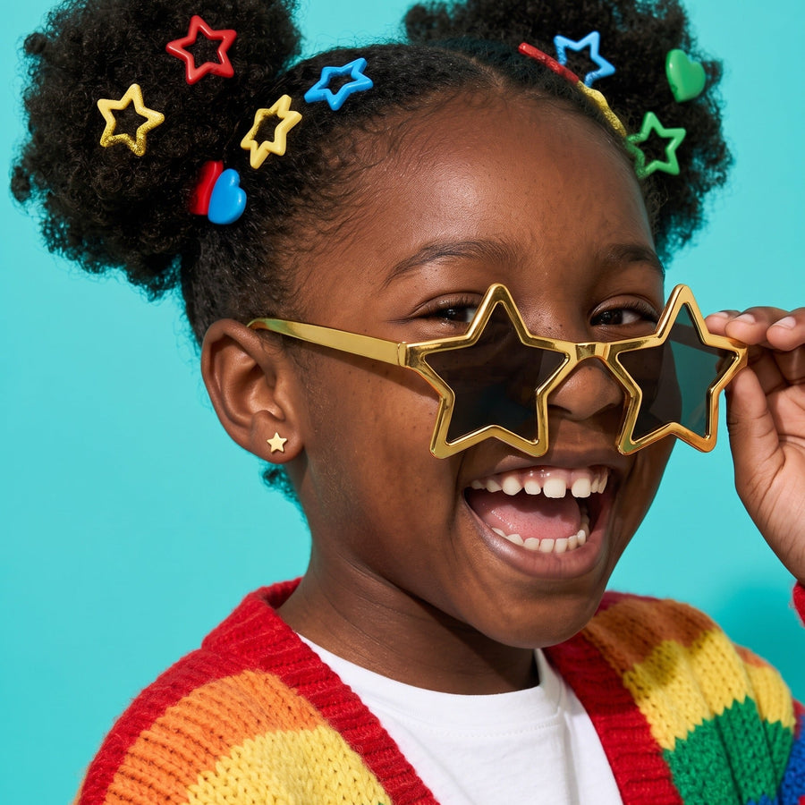 Star Flat Back Studs Gold worn by a smiling girl, rainbow knit look: hypoallergenic kids' earrings