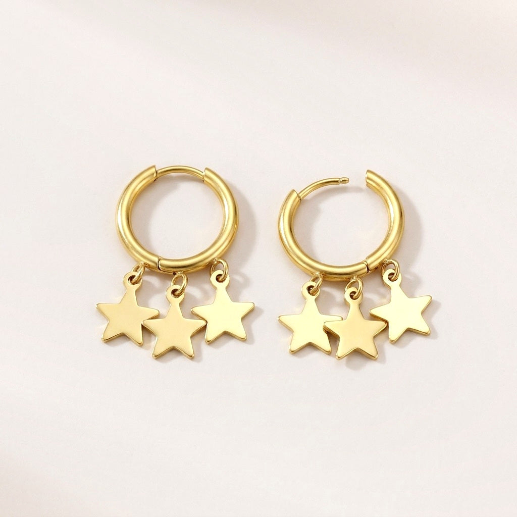 Starfall Huggies: hypoallergenic huggie hoop earrings, shown front and side on a soft stone background