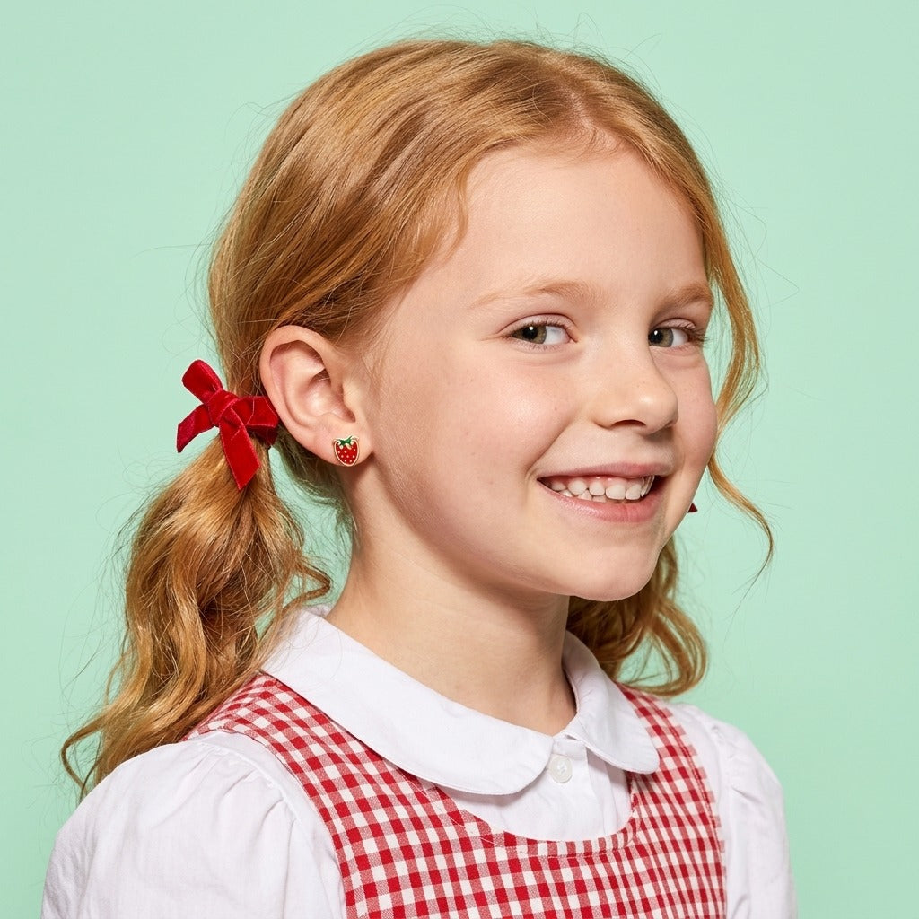 Strawberry Delight Flat Back Studs Gold worn by a smiling girl in a red gingham dress with red hair bows