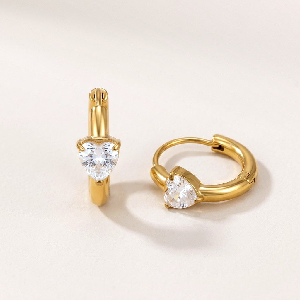 Sweetheart Spark Huggies Gold: hypoallergenic huggie hoop earrings, shown front and side on a soft stone background