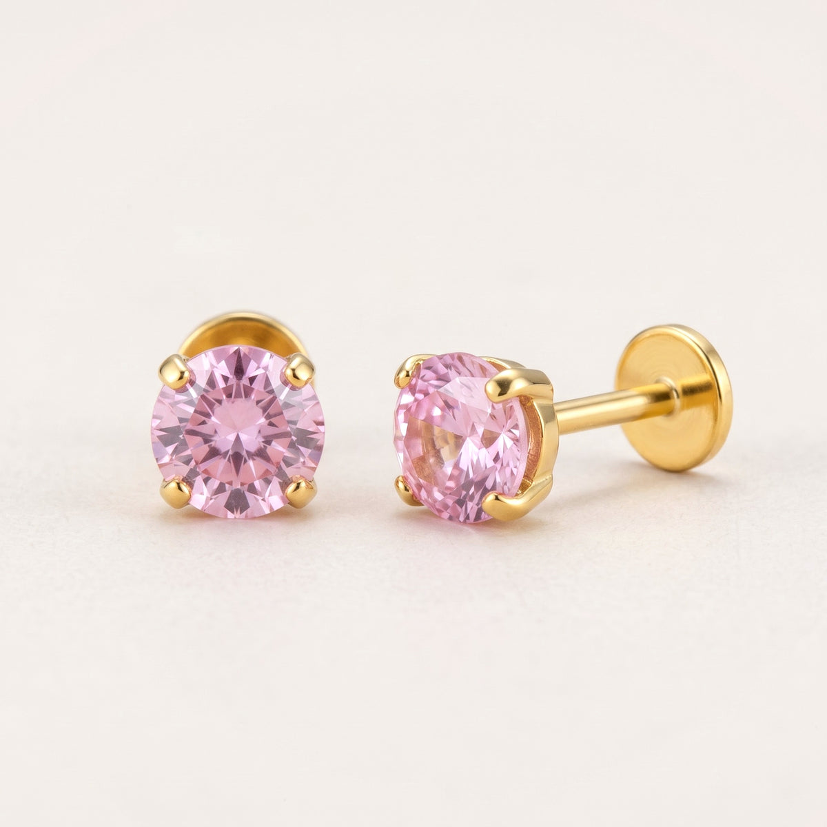 The Birthstone Flat Back Studs Gold in Pink Tourmaline: hypoallergenic kids' flat back stud earrings, shown front and side on a soft stone background