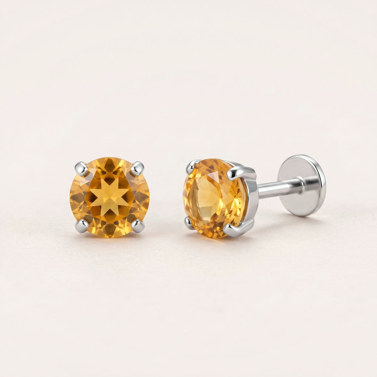 The Birthstone Flat Back Studs Silver in Citrine: hypoallergenic kids' flat back stud earrings, shown front and side on a soft stone background