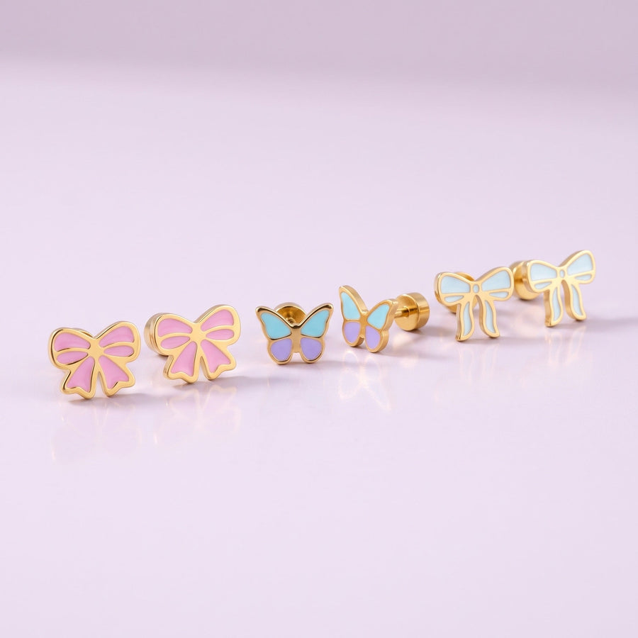 Candy Bow Flat Back Studs + Flutter Flat Back Studs + Frosted Bow Flat Back Studs: three hypoallergenic kids' earrings styled together on a soft background
