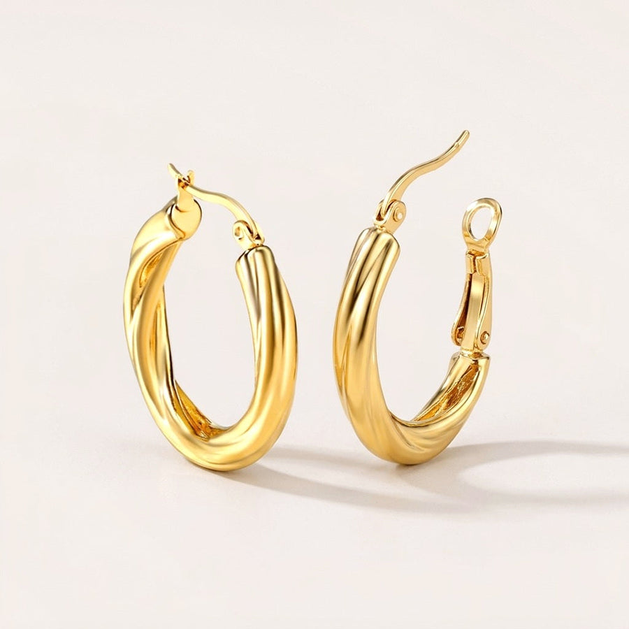 Twisted Hoops Gold: hypoallergenic hoop earrings, shown front and side on a soft stone background
