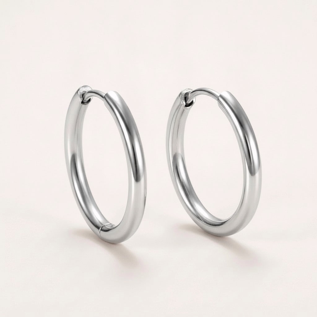 Everyday Hoops Silver: hypoallergenic kids' hoop earrings, shown front and side on a soft stone background