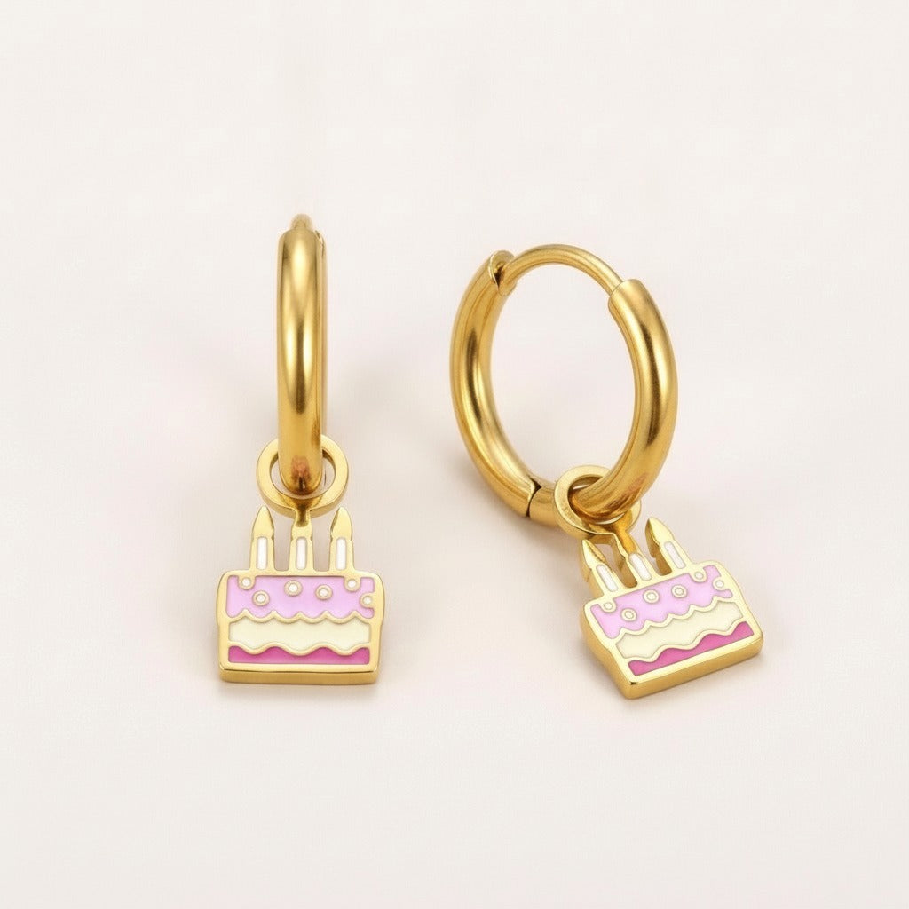 Party Cake Huggies: hypoallergenic kids' huggie hoop earrings, shown front and side on a soft stone background