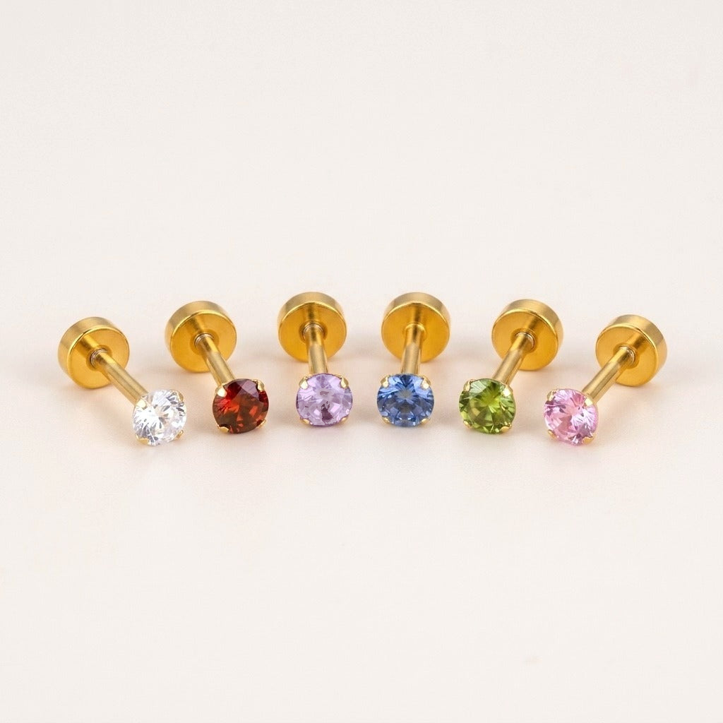 The Birthstone Flat Back Studs Gold: hypoallergenic kids' flat back stud earrings in birthstone colours, on a soft stone background