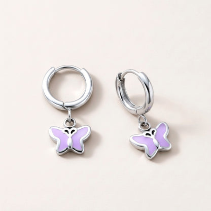 Butterfly Flutter Huggies Silver: hypoallergenic kids' huggie hoop earrings, shown front and side on a soft stone background