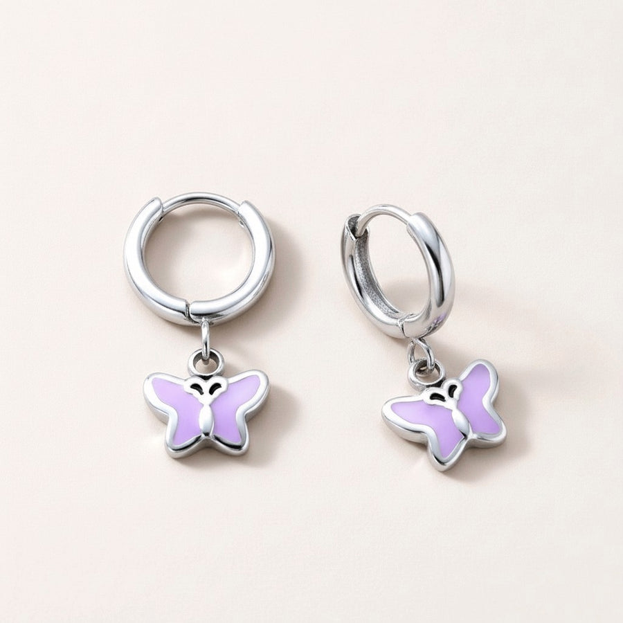 Butterfly Flutter Huggies Silver: hypoallergenic kids' huggie hoop earrings, shown front and side on a soft stone background