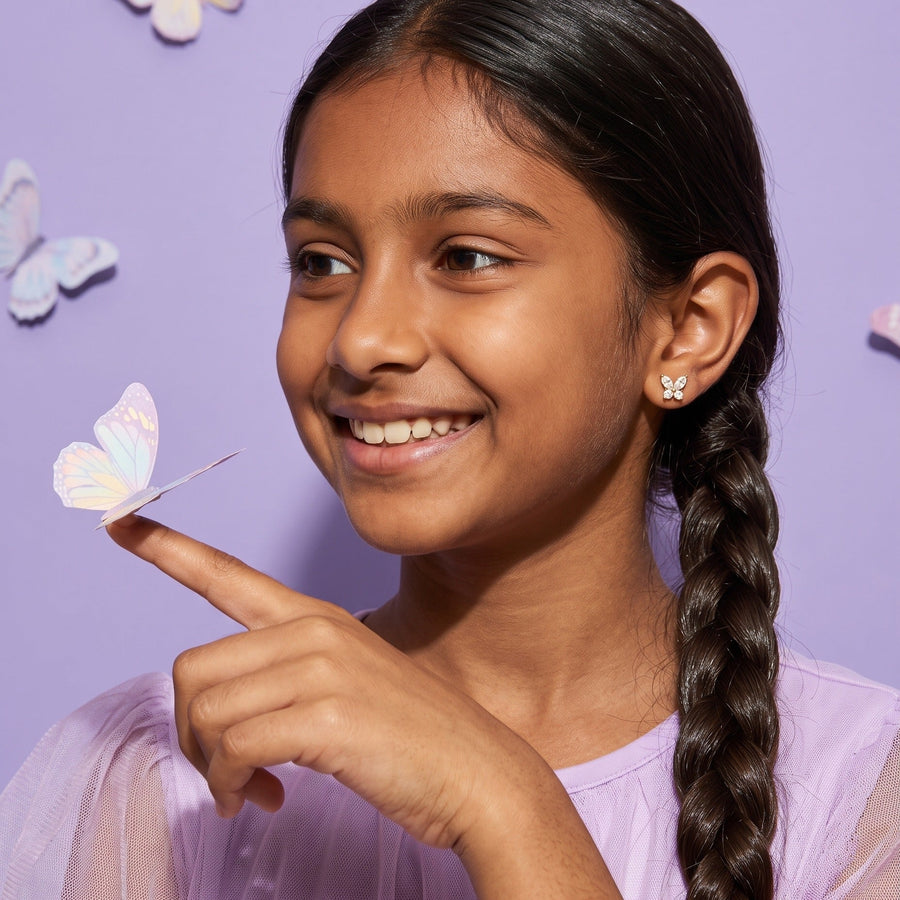 Crystal Flutter Screw Back Studs worn by a smiling girl, bows butterflies look: hypoallergenic kids' earrings