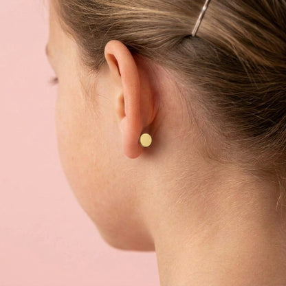 Back of the ear: the flat disc back sits neatly behind the lobe (gold)