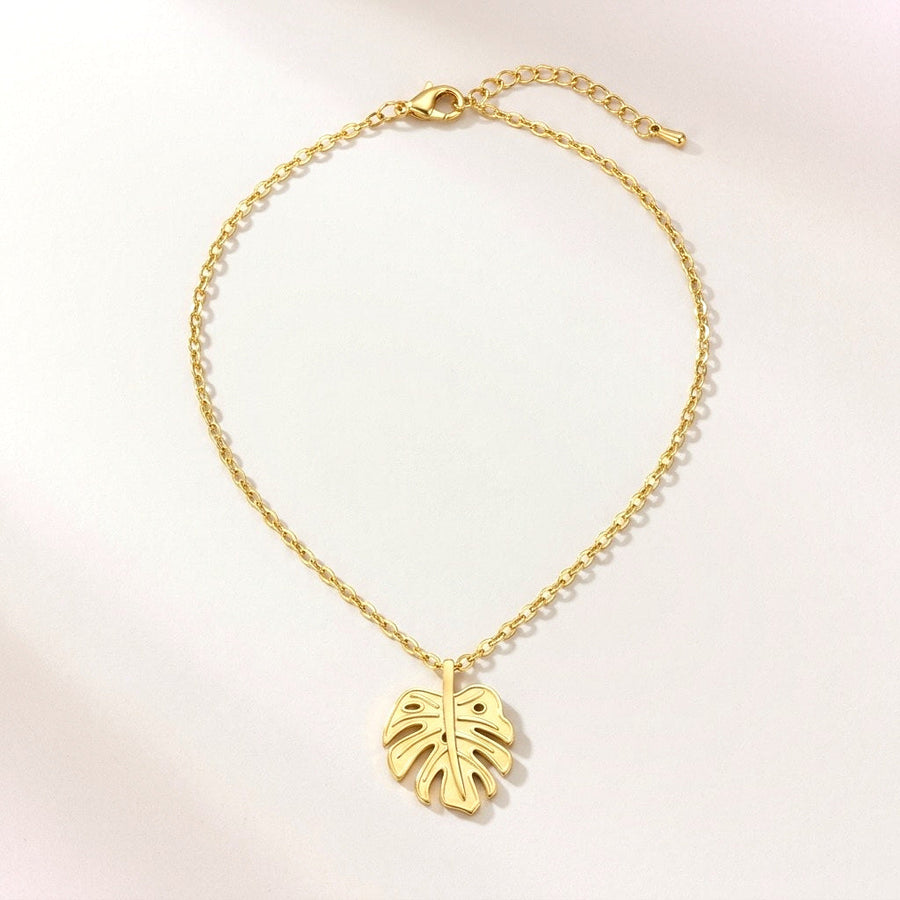 Golden Monstera Necklace: hypoallergenic necklace, shown front and side on a soft stone background
