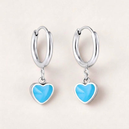 Heart Huggies Silver in Turquoise: hypoallergenic kids' huggie hoop earrings, shown front and side on a soft stone background