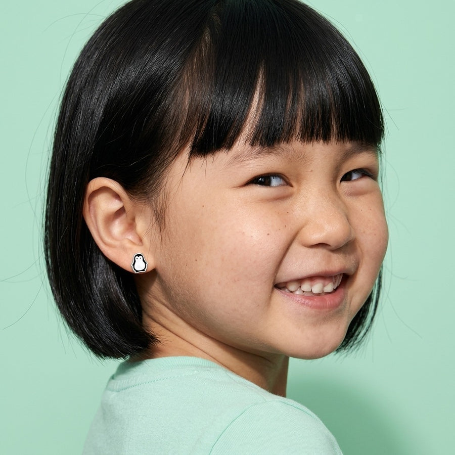 Penguin Flat Back Studs Silver worn by a smiling girl