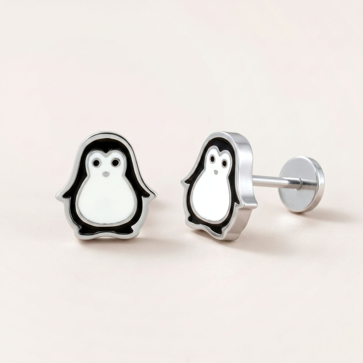 Penguin Flat Back Studs Silver: hypoallergenic kids' flat back stud earrings, shown front and side on a soft stone background