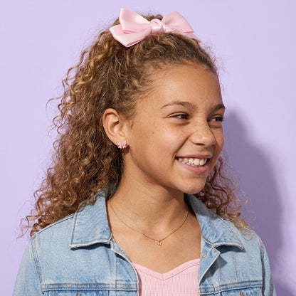 Candy Bow Flat Back Studs worn by a smiling girl in a denim jacket with a pink hair bow
