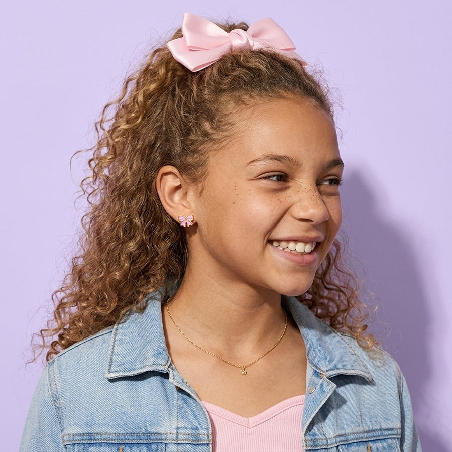 Candy Bow Flat Back Studs worn by a smiling girl in a denim jacket with a pink hair bow