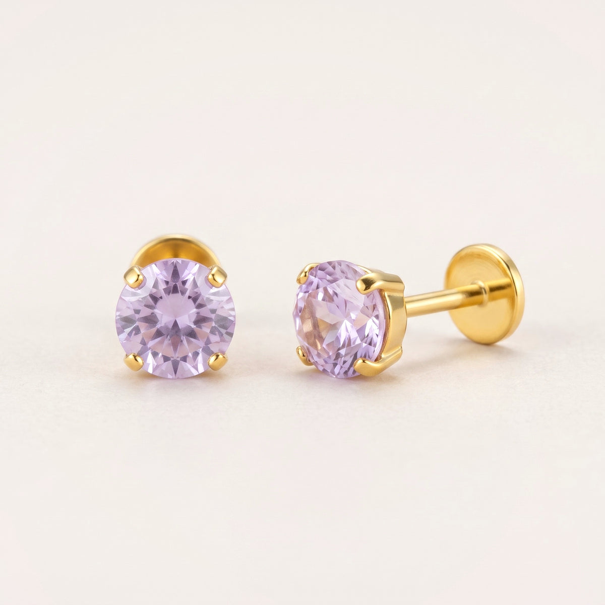 The Birthstone Flat Back Studs Gold in Amethyst: hypoallergenic kids' flat back stud earrings, shown front and side on a soft stone background