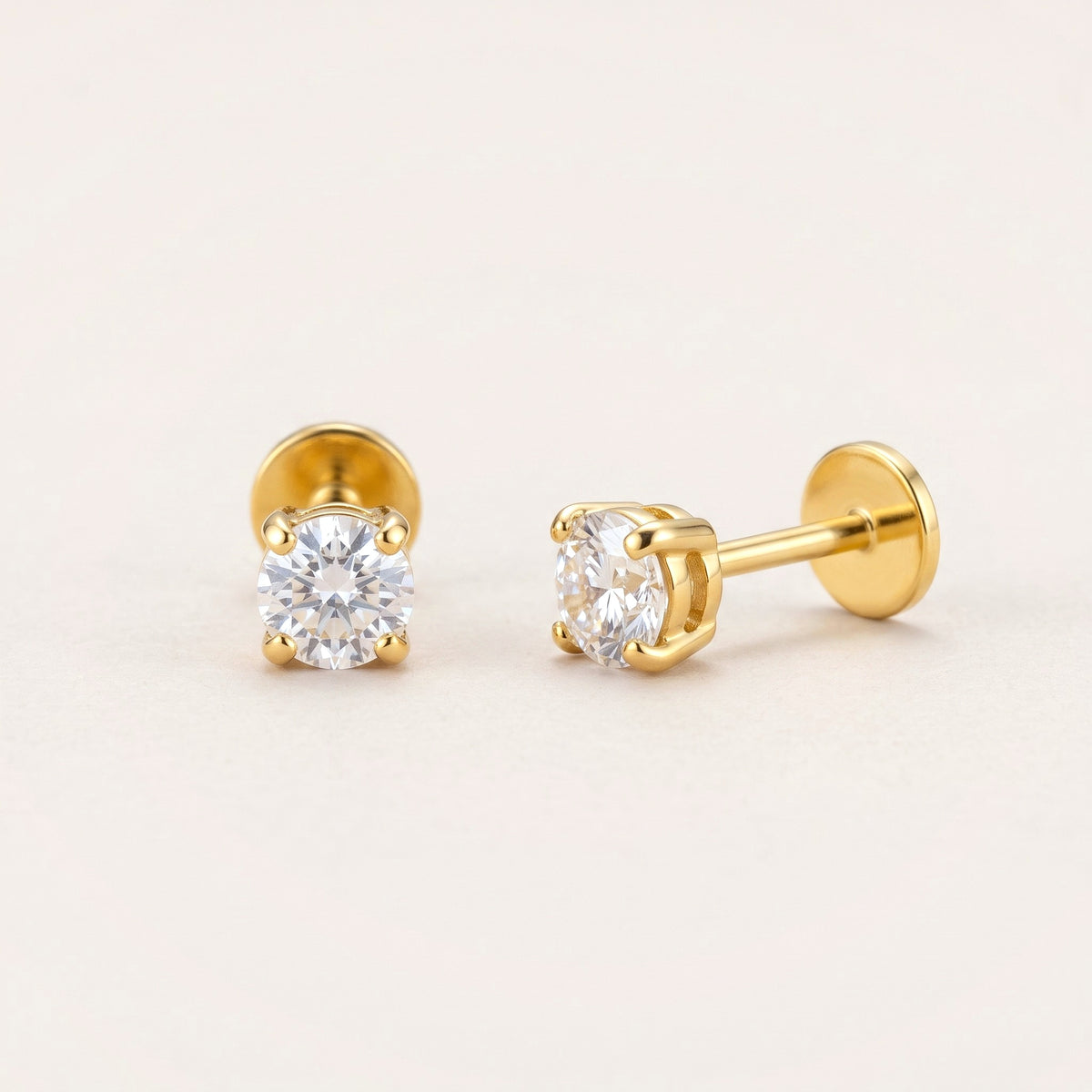 The Birthstone Flat Back Studs Gold in Diamond: hypoallergenic kids' flat back stud earrings, shown front and side on a soft stone background