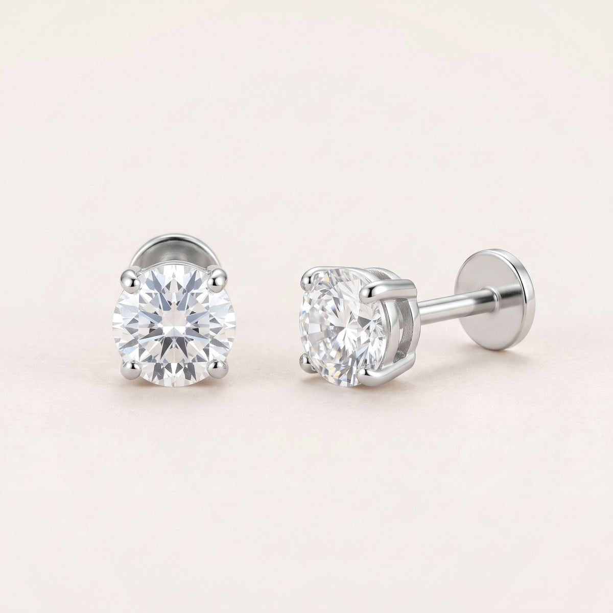 The Birthstone Flat Back Studs Silver in Diamond: hypoallergenic kids' flat back stud earrings, shown front and side on a soft stone background