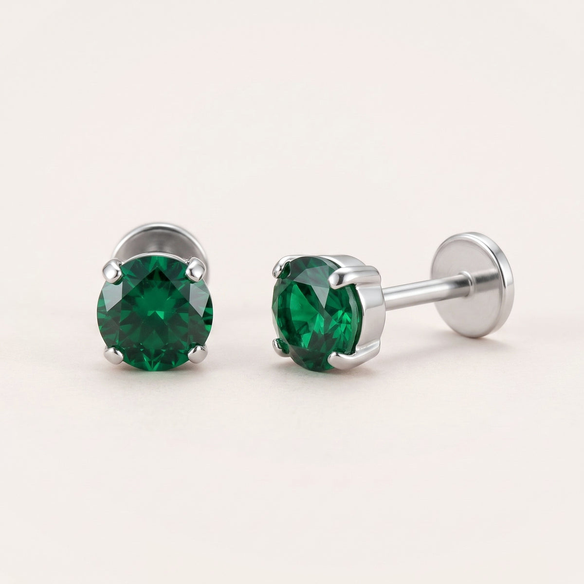 The Birthstone Flat Back Studs Silver in Emerald: hypoallergenic kids' flat back stud earrings, shown front and side on a soft stone background