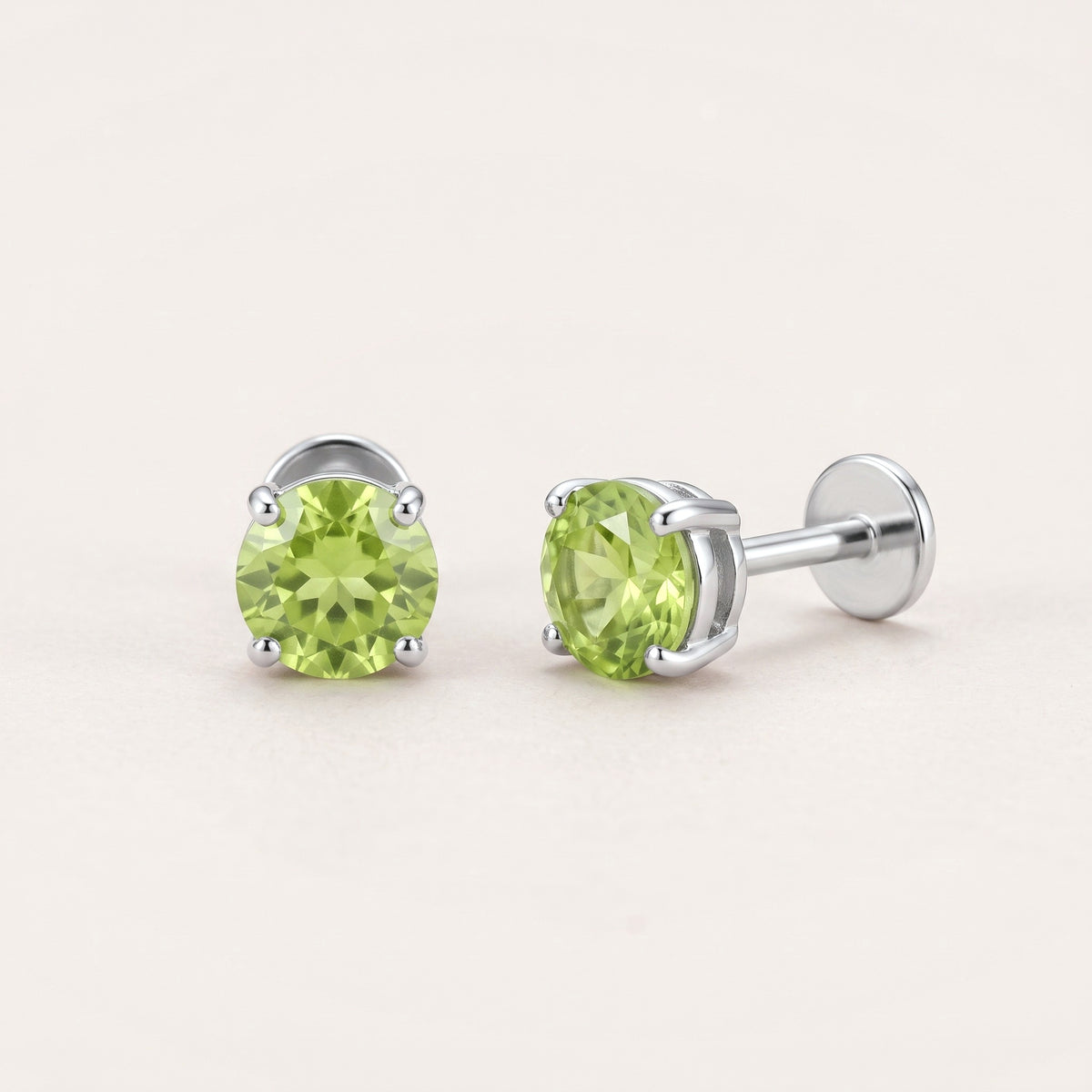 The Birthstone Flat Back Studs Silver in Peridot: hypoallergenic kids' flat back stud earrings, shown front and side on a soft stone background
