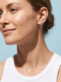 Woman wearing Delilah silver hoop earrings
