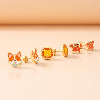 Corgi Flat Back Studs Gold + Little Lion Flat Back Studs Gold + Crabby Flat Back Studs Gold: three hypoallergenic kids' earrings styled together on a soft background