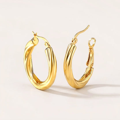 Twisted Hoops Gold: hypoallergenic hoop earrings, shown front and side on a soft stone background