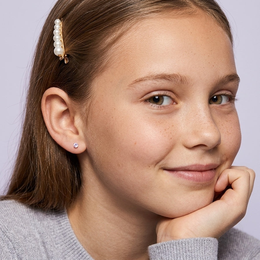 June birthstone earrings: alexandrite colour flat back stud worn by a smiling girl