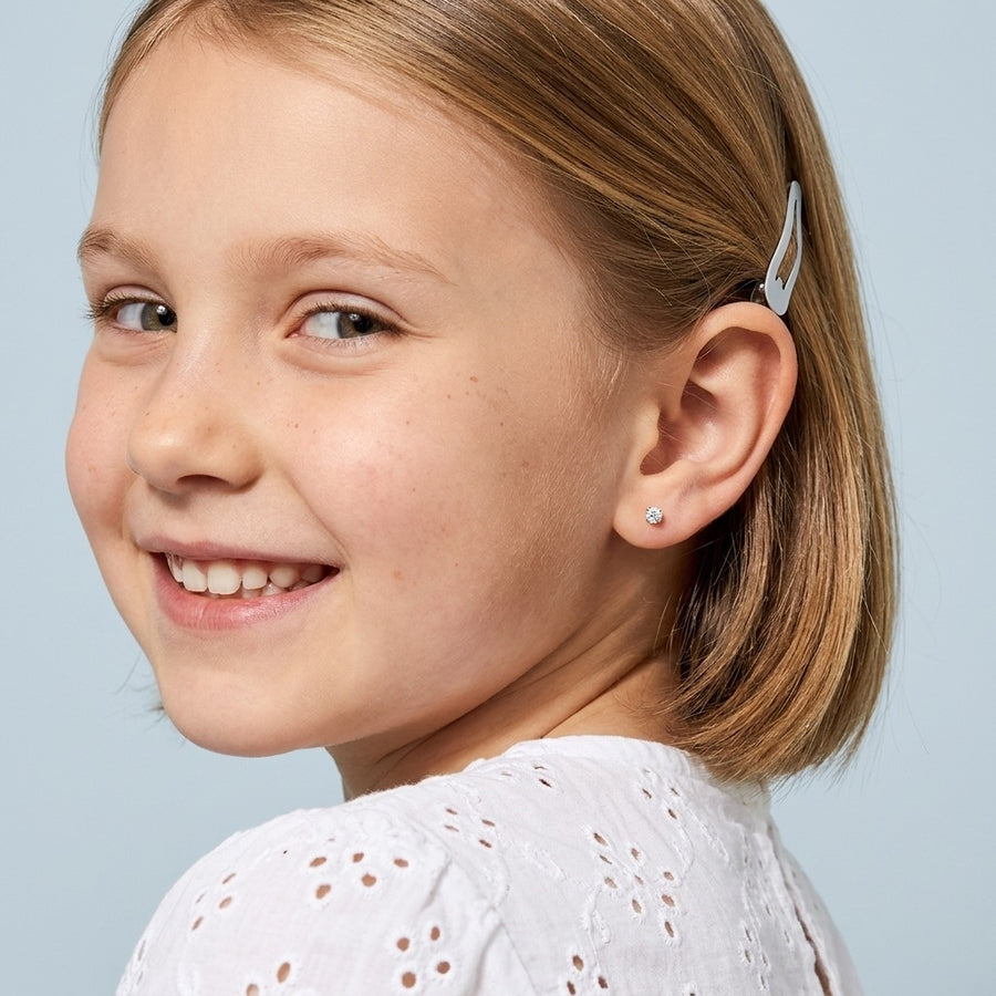 April birthstone earrings: clear diamond colour flat back stud worn by a smiling girl