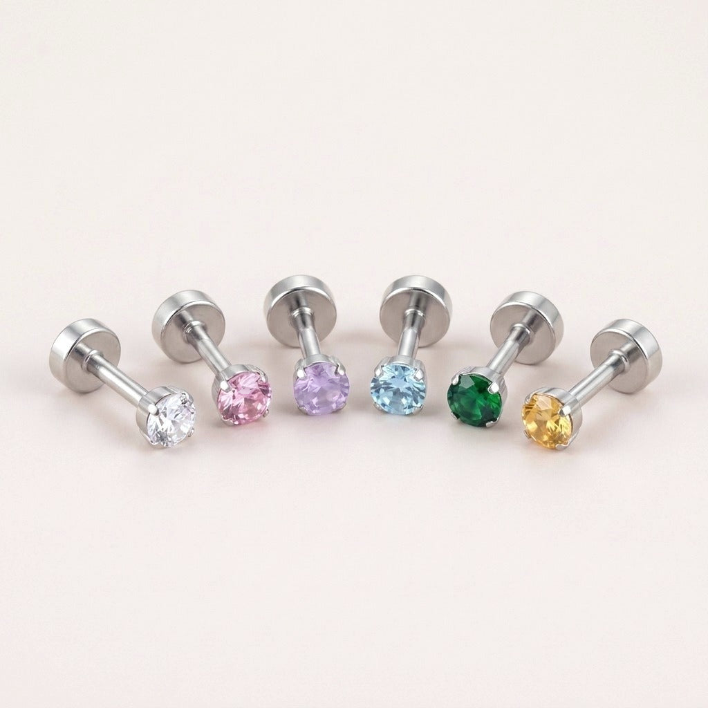 The Birthstone Flat Back Studs Silver: hypoallergenic kids' flat back stud earrings in birthstone colours, on a soft stone background