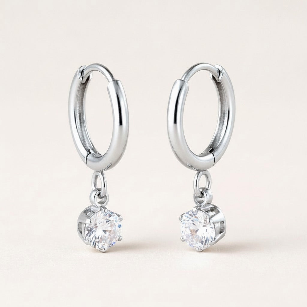 Twinkle CZ Diamond Huggies Silver: hypoallergenic kids' huggie hoop earrings, shown front and side on a soft stone background