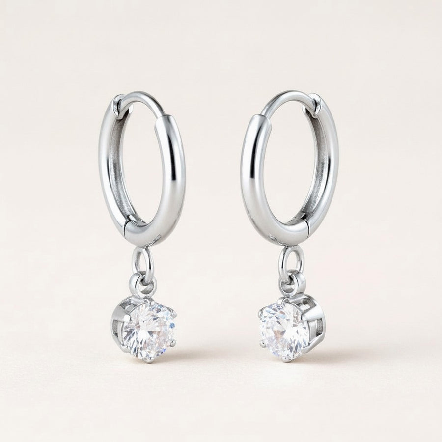 Twinkle CZ Diamond Huggies Silver: hypoallergenic kids' huggie hoop earrings, shown front and side on a soft stone background